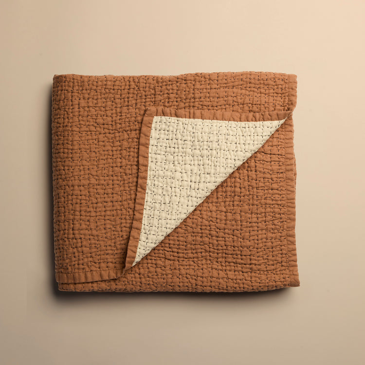 Copper textured blanket reversible to ivory on a beige background
