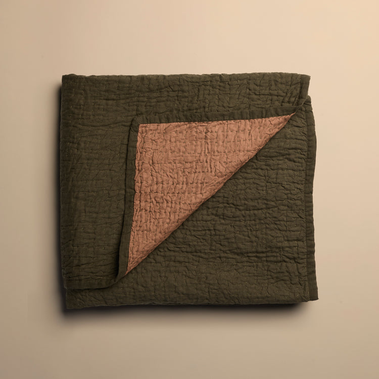 Folded reversible quilt with textured surface on a beige background