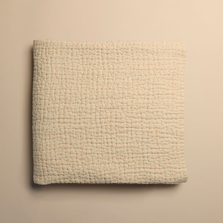 ivory textured blanket on a beige background