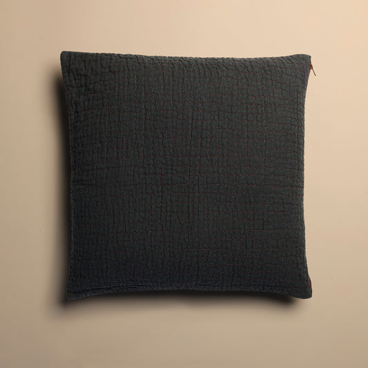 Dark blue textured pillow on a beige background