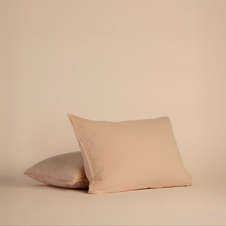Two peach shams on pillows on a beige background