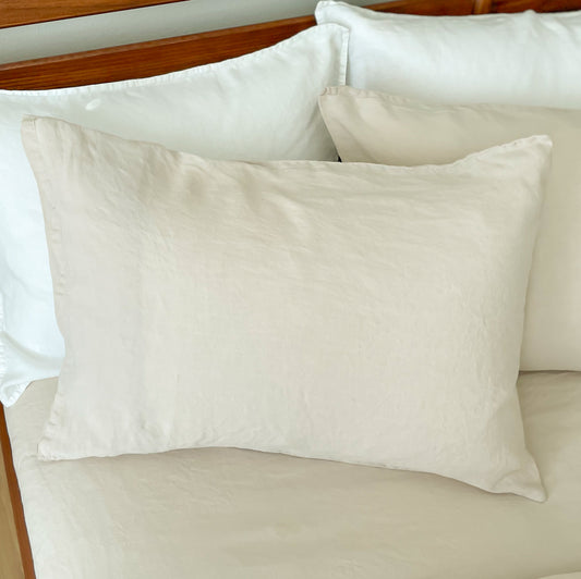 Beige pillows on a bed with wooden headboard
