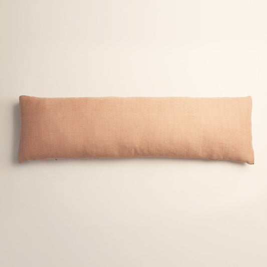 Long rectangular pink/beige cushion on a light beige background
