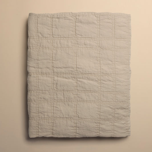 beige quilt folded on beige background