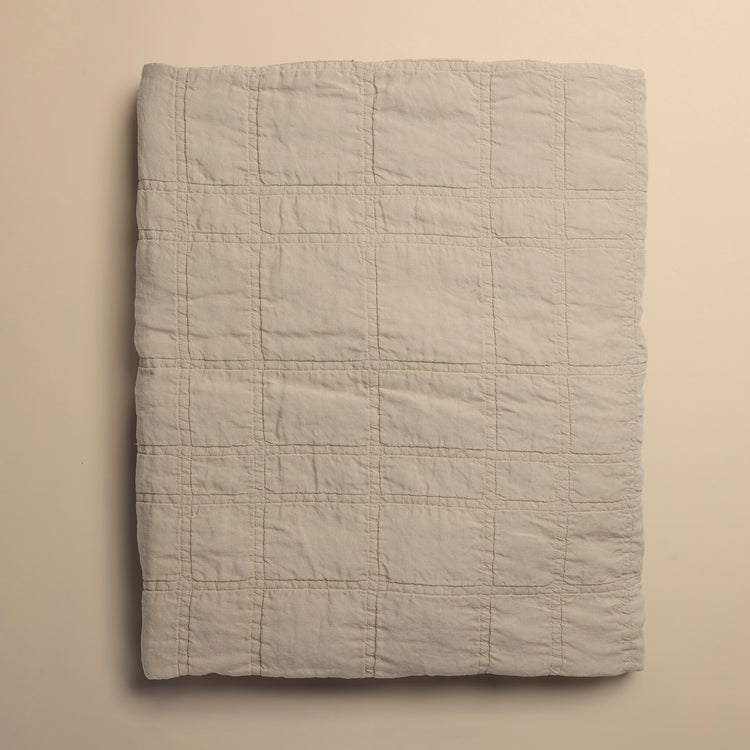 beige quilt folded on beige background