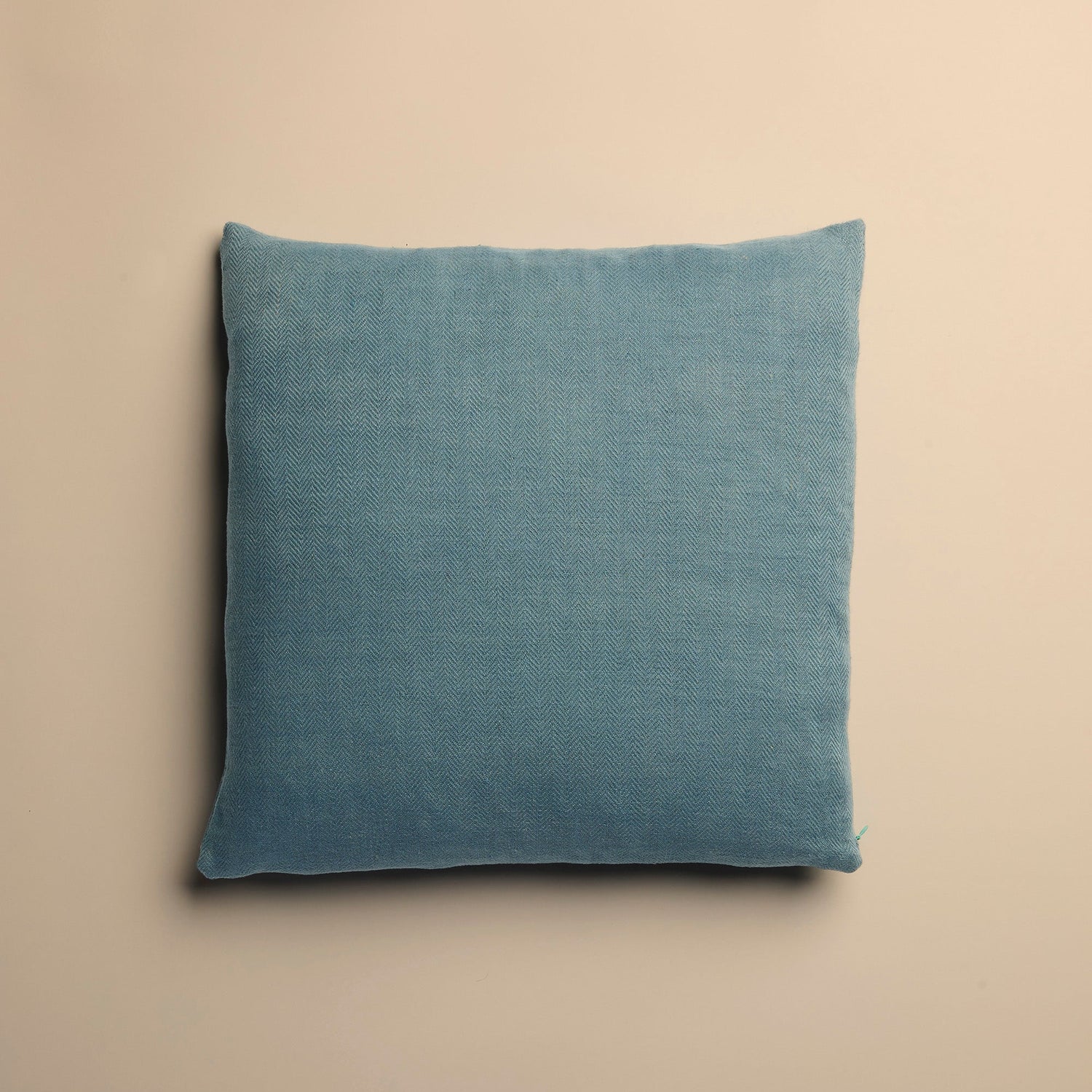 Blue pillow on a beige background