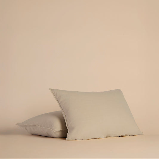 Two light beige shams and pillows with a beige background