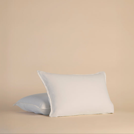 Two white pillowcases and pillows on a beige background