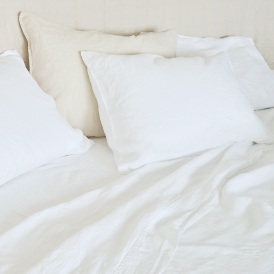 Hemp Sheets in white on bed with a natural headboard