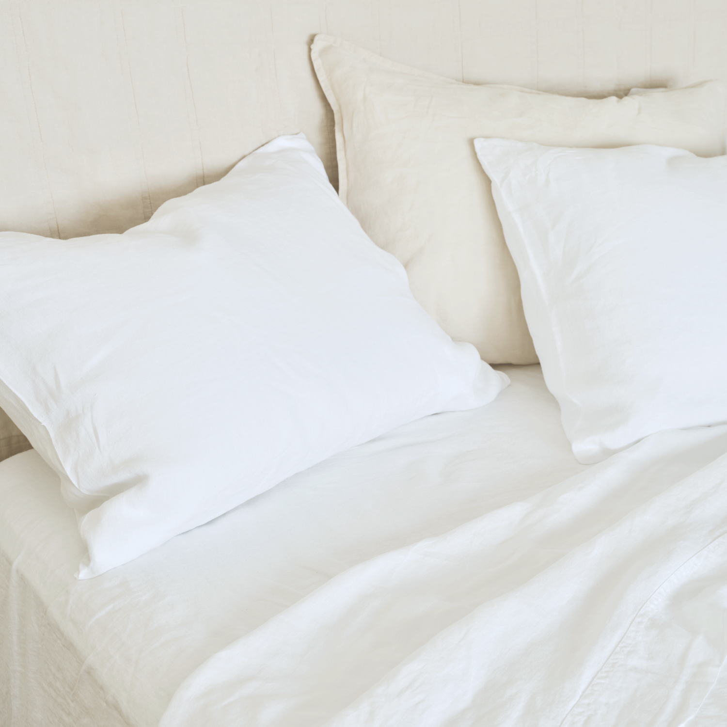 cool, relaxed white hemp sheets on bed with natural headboard