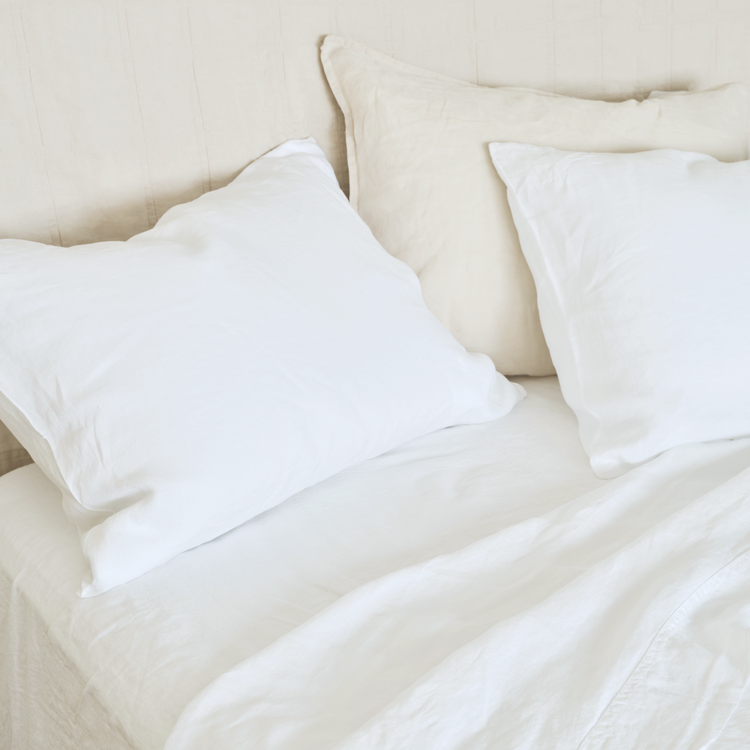cool, relaxed white hemp sheets on bed with natural headboard